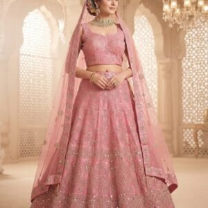 bridal elegance with this luxurious Soft Rose Pink Lehenga Set. Meticulously crafted from premium Satin Silk, this ensemble features intricate silver-gold zari embroidery paired with shimmering mirror work and delicate floral motifs. The full-length flared lehenga is adorned with decorative tassels and an ornate multi-tier border, while the sleeveless scoop-neck blouse showcases a sophisticated diamond grid pattern. Complete with a matching sheer net dupatta, this set is a masterpiece of traditional Indian craftsmanship blended with modern style.